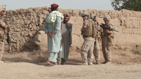 Afghanistan - February 16, 2008: A group of Afghan men providing information to American soldiers