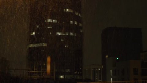 City buildings obscured by heavy rain at night