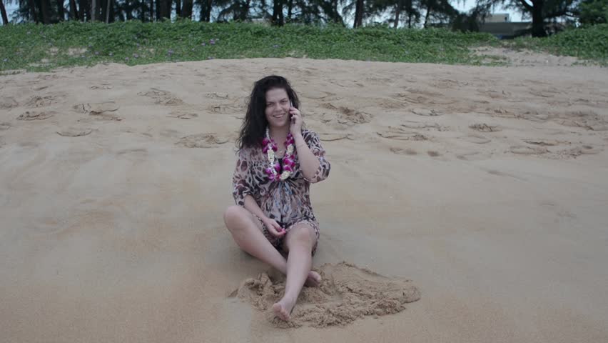 Girl look smart phone while sitting on the beach