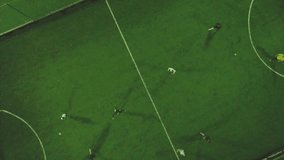 Aerial football match play. Clip. Aerial shot Two teams playing ball in football outdoors, top view. Football game outdoors, green field with markings, players running around with a ball