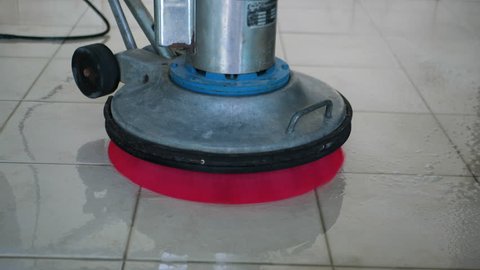 Silhouette cleaning floor with machine.