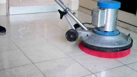 Silhouette cleaning floor with machine.