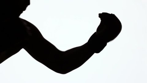 Silhouette of a sporting young man during martial arts classes. Sports combat training. An Asian fighter without rules trains blows with his hands and knees. Black object isolated on white background.