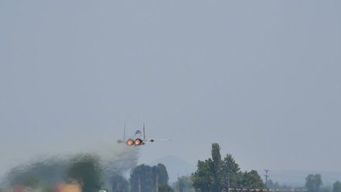 Full Afterburner Military Combat Jet Aircraft just after Takeoff in Slow Motion 96fps Low Pass over the Runway. United States Air Force McDonnell F 15 Eagle at Graf Ignatievo Air Base 24 June 2016