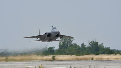 Military Combat Jet Aircraft just after Takeoff in Slow Motion 96fps Low Pass over the Runway. United States Air Force F-15C Eagle (Boeing Defense) at Graf Ignatievo (Plovdiv) Air Base 24 June 2016
