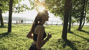 Athletic woman wearing sportswear running in park on sunny day