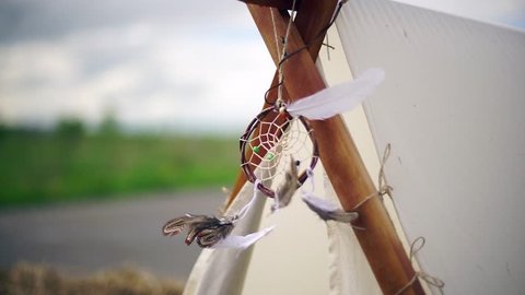 The amulet of feathers hangs on the wigwam.