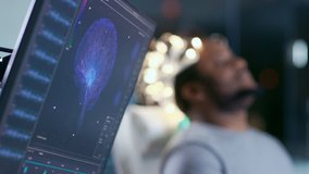In Laboratory Man Wearing Brainwave Scanning Headset Sits in a Chair with Closed Eyes. Monitors Show EEG Reading and Graphical Brain Model. In the Modern Brain Study/ Neurological Research Laboratory. - Powered by Shutterstock - Get 15% off with code: PIKWIZARD15