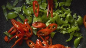 Green and red peppers for fajita in a frying pan. Video