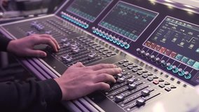 Close- up. Hand of the sound producer. Professional audio operator working on audio mixer knobs. Controls of video and audio mixing console, close up of hands using it slow motion