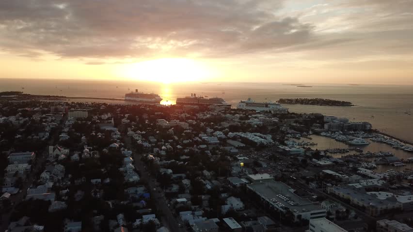 Aerial drone view of downtown Key West during sunset and some cruise ships at port. 