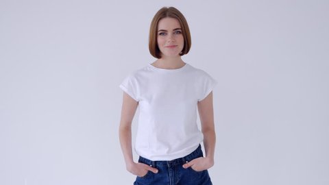 Beautiful woman folded arms while posing in jeans shorts and white T-shirt