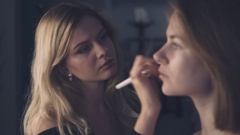 Makeup artist applying tone on model face