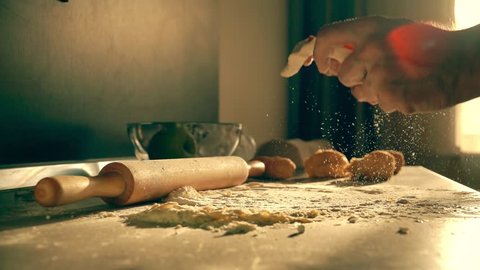 Male cook throwing homemade pasta dough on the table, super slow motion shot
