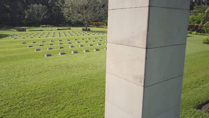 A medium shot of a tombstone and trees. Camera moves up