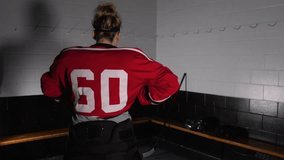 woman hockey player slides jersey on depth of field in changeroom - Powered by Shutterstock - Get 15% off with code: PIKWIZARD15