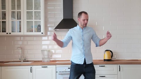 man dancing and singing in the kitchen