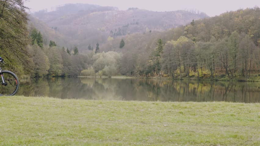 Young man riding bicycle outside in autumn nature.