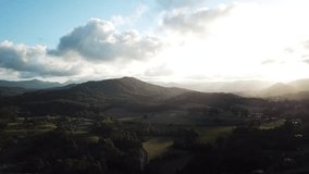 Slow pan of sunset, drone view. Sunlight casting gold light over landscape.