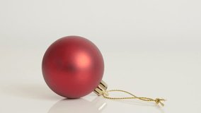 Tilting on Christmas ornament on white background close-up 4K 2160p 30fps UltraHD footage - Matte red color shiny bauble slow tilt 3840X2160 UHD video