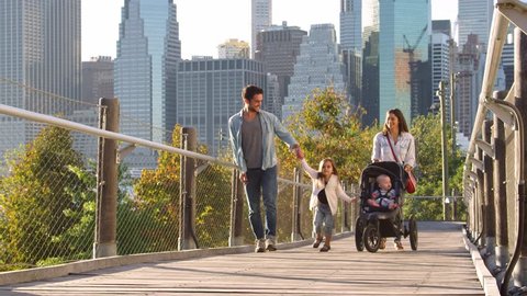 Young family walking with stroller on footbridge, Manhattan