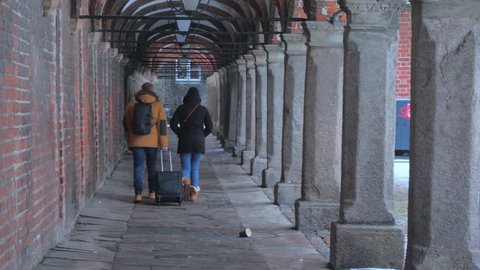 LUBECK, GERMANY - FEBRUARY 11, 2018. Strolling tourists and Arcades under the old town building in Lubeck, Germany