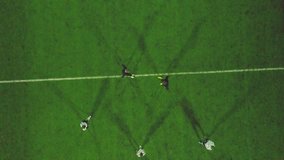 Aerial view of football pitch at night with amateur football players playing the game in the city. Clip.