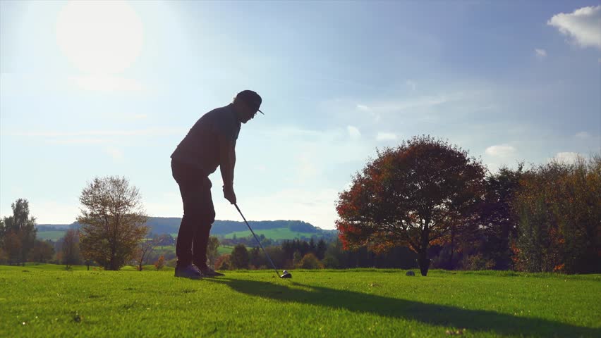 Golf Player plays golf on a beautiful summer morning. wide angle Lens flare Back lite shot  Royalty-Free Stock Footage #1007688808