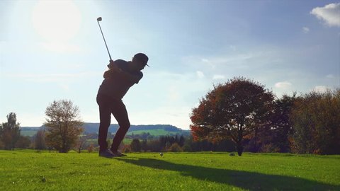 Golf Player plays golf on a beautiful summer morning. wide angle Lens flare Back lite shot 