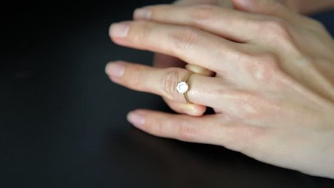 Remove engagement wedding ring from ring finger. Concept of divorce, marriage problem.