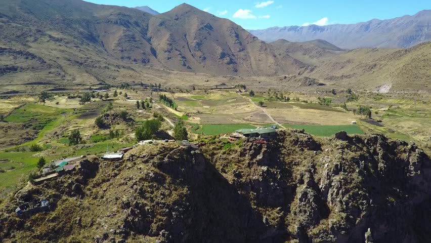 Stunning cinematic aerial flying backwards over the Colca Canyon valley in Peru along the Andes Mountain range