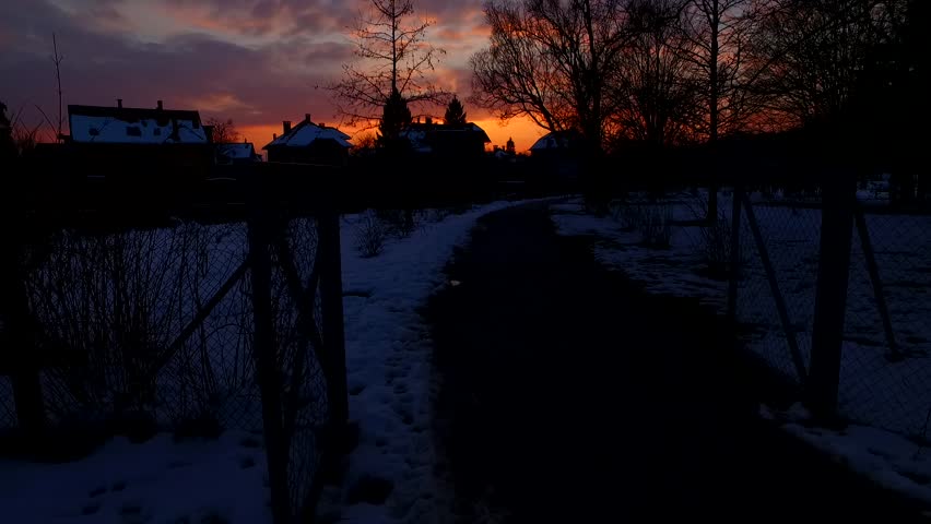 Silhouettes of a small town at the end of a frozen winter day whit bold, magnificent sunset.