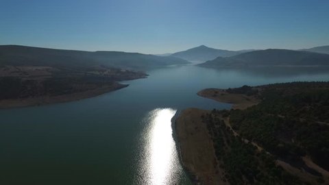 Aerial View. Flying over the beautiful lake near mountains. Aerial camera shot. Landscape panorama.
