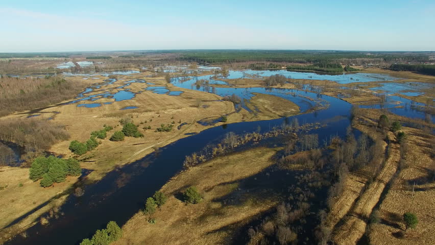 4K. Flight over flooded blue river in early spring, aerial panoramic view.