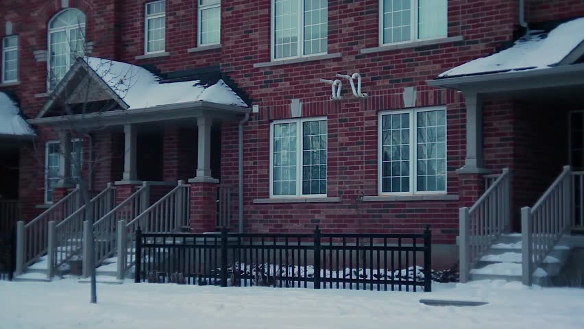 Ambiguous Suburb streets in the winter. Slow tilt up on townhouses
