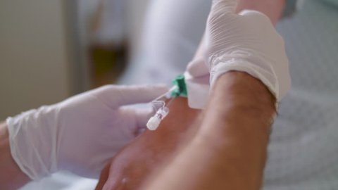 Pregnant woman becoming Intravenous infusion needle in hand vein for infusion.