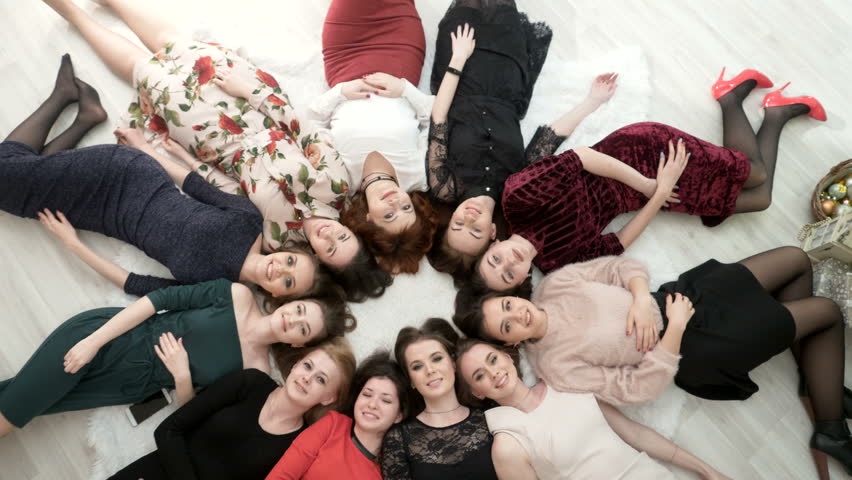Top view on happy women in dress lying on the floor.