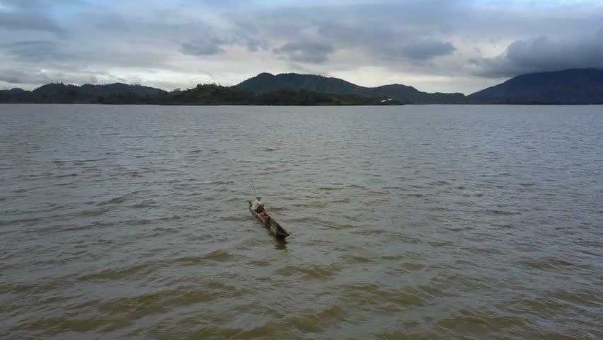 pictorial upper panorama boundless dark grey lake and boat small silhouette against highland landscape