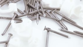 White plastic staples with nails for fixing wires