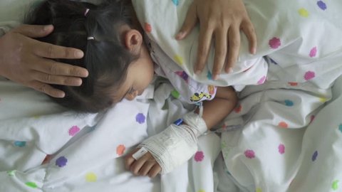 Sick asian child girl with hand bandaged hugging her mother with love in the hospital in slow motion shot