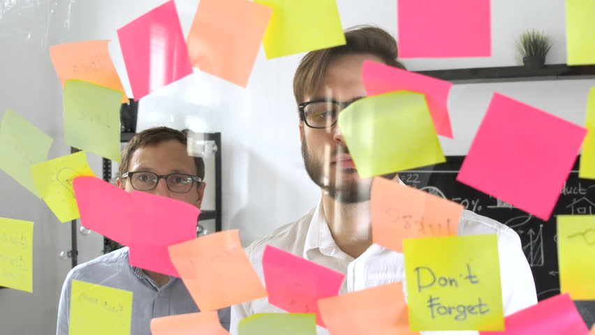 Man post in sticky note while meeting in office on the sticker is written N1 number one