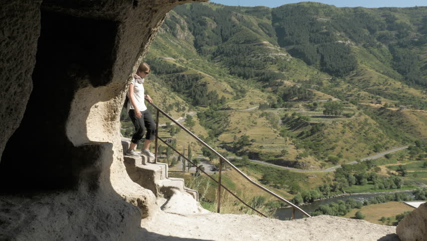 Young girl walks the stairs in cave monastery Vardzia - Georgia