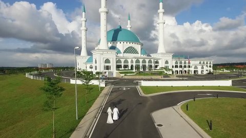 December 2017,Johor Bharu,Malaysia.Real time aerial footage of husband and wife walking toward a beautiful Mosque.Aerial footage of Sultan Iskandar Mosque located in Dato Onn Town in south Malaysia.