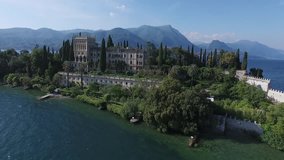 castle. Panorama of the gorgeous Lake Garda surrounded by mountains, Italy. video shooting with drone