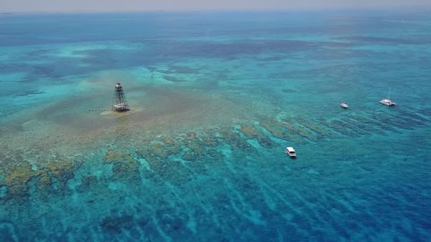 Aerial view of Sand Key LightHouse Reef outside of Key West Florida. Filmed from a DJI Mavic Pro on a warm sunny summer day. Part of John Pennekamp state park, it's a major tourist attraction for FL.
