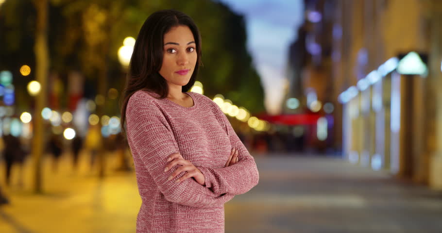 Pretty Latin woman posing for a portrait outside. Casual portrait of Mexican woman smiling at camera in evening. 4k