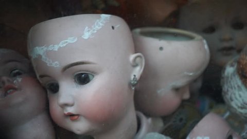 heap of pieces of dolls piled up in a showcase of a toy restorer. image for horror, psychological, fear concept