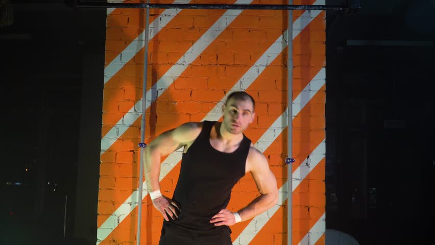 athlete makes a workout opposite the red wall