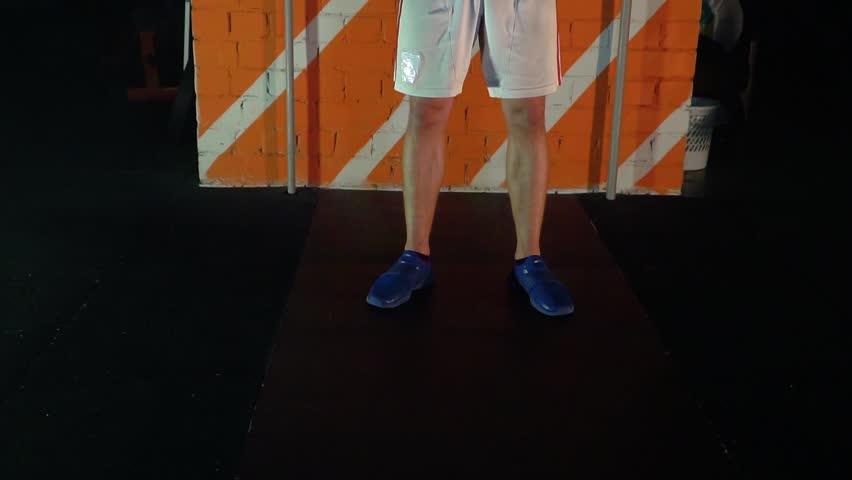 athlete makes a workout opposite the red wall