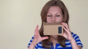 Emotional girl put virtual cardboard glasses and try to catch something. Happy smiling woman face. Closeup shot. 4K